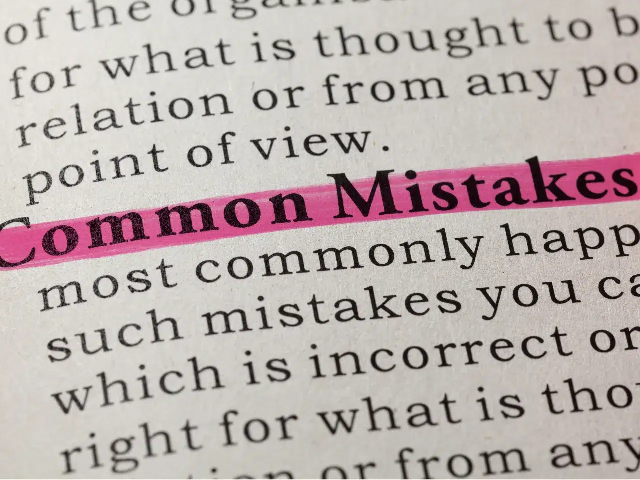 A close-up of a book page with the words Common Mistakes highlighted in pink. The surrounding text is slightly blurred, drawing attention to the highlighted words.
