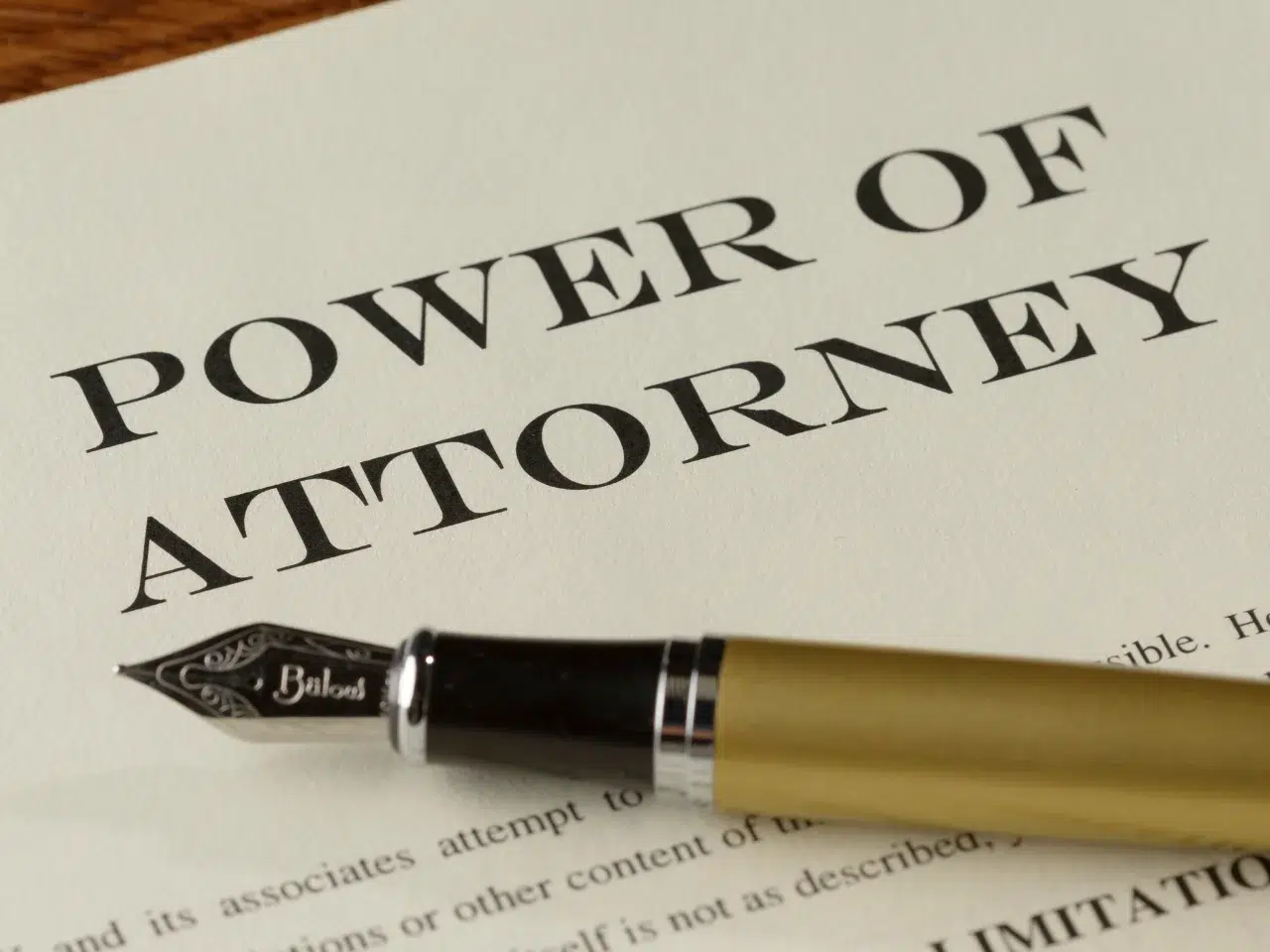 A close-up of a document titled Power of Attorney with a gold and black fountain pen resting on top of the paper.