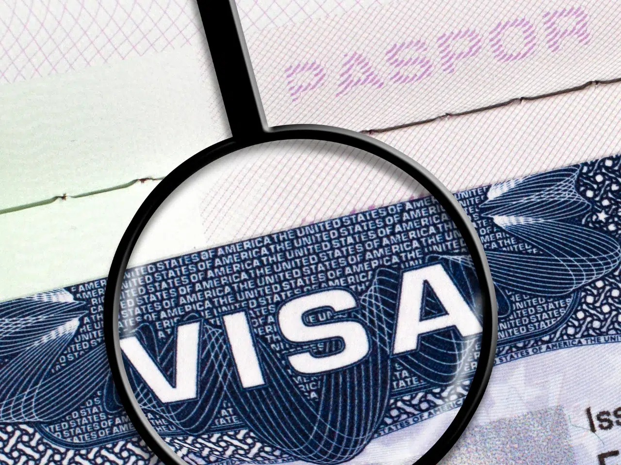 A magnifying glass focuses on the word VISA printed on a U.S. visa page, partially overlaid on a passport, with PASSPORT faintly visible at the top.